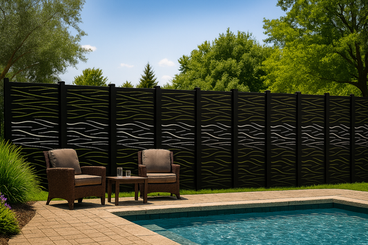 Two brown chairs with cushions by a poolside against a decorative black fence.